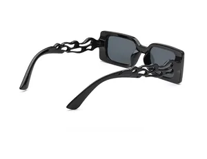 Detail view of square black sunglasses with unique flame cutout temples and grey lenses