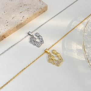 Detail of mother and child pendant necklace with sparkling zircon pavé on beige stone