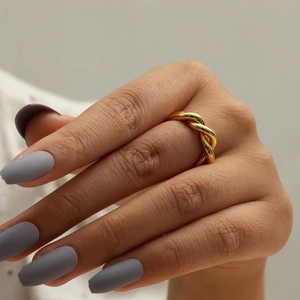 Detail shot of a minimalist twisted rope ring in gold-plated brass on a finger