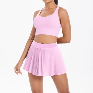 Detail of pink yoga set featuring a criss-cross back sports bra and pleated tennis skirt