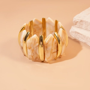 Détail du bracelet en acrylique irrégulier avec métal doré et texture marbrée