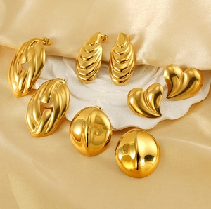 Detailed view of 18K gold-plated stainless steel liquid heart and textured earrings on silk