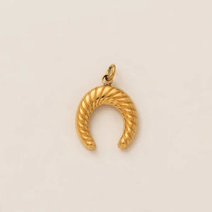 Detailed macro view of gold-plated horseshoe pendant with twisted texture finish