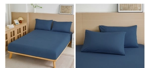 Detail of dark blue fitted sheet and pillowcase set with smooth cotton fabric texture