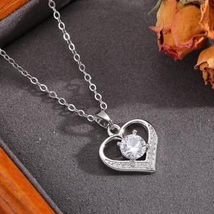 Dettaglio macro della collana a cuore in argento con zirconi su superficie scura