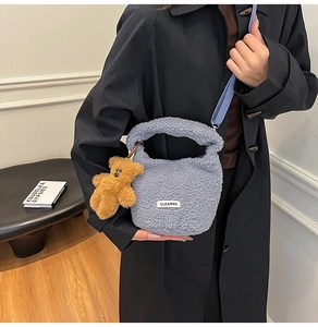 Détail du sac seau en peluche gris clair avec charm ours et bandoulière réglable
