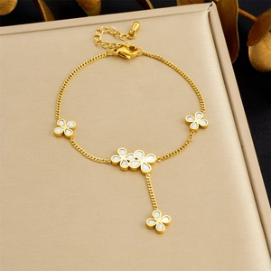 Detailed shot of gold chain bracelet with white clover charms and lobster clasp closure