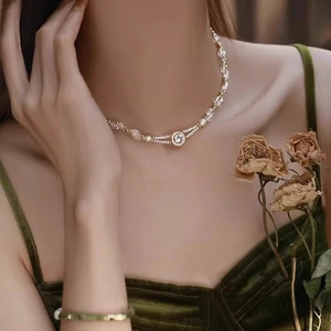 Detail of beaded necklace with zircon pendant on green velvet dress in vintage style
