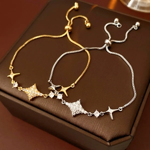 Macro detail of adjustable star charm bracelets in gold and silver with white zircon