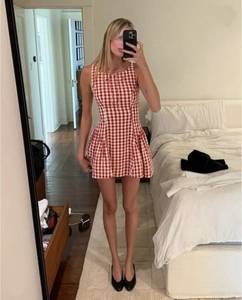 Détail de la robe à carreaux vichy rouge et blanc avec taille ajustée et nœud au col