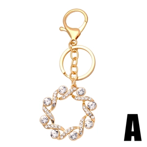 Portachiavi a forma di girasole dorato con strass e moschettone su sfondo bianco