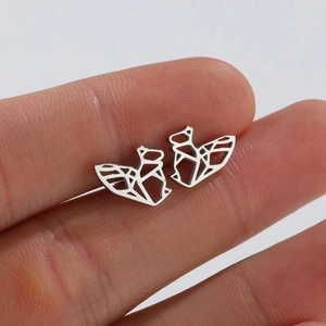Macro view of geometric squirrel stud earrings in silver stainless steel on hand