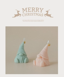 Detailed view of handmade Christmas gnome candles with gold bells and pointed hats