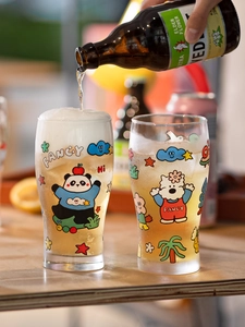 Detailed shot of beer being poured into cute panda and dog pattern glass tumblers