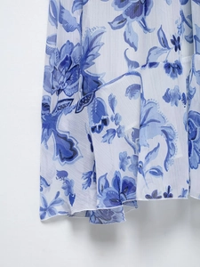 Gros plan sur l'imprimé orchidée de cette robe midi en mousseline au drapé élégant