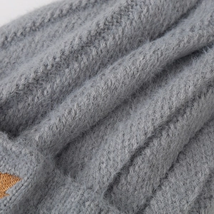 Macro shot of grey long-haired knit fabric with fuzzy mohair texture and embroidery