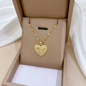 Macro detail of a heart-shaped gold necklace with tulip design and crystals in a box