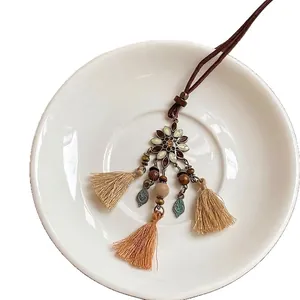 Collier bohème avec pendentif fleuri, glands vintage, perles en bois et breloque