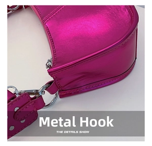 Detail of silver hardware hooks and metal rivets on shiny metallic pink PU shoulder bag
