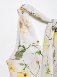 Detailed close-up of floral print halter tie-neck on a light chiffon summer dress