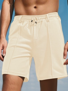 Detail of men's beige mesh sports shorts showing breathable fabric and drawstring waist