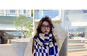 Close-up of soft blue and white checkered knit scarf styled with classic glasses