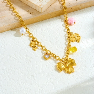 French vintage gold necklace with bow, heart zircon, pearl and flower pendants on stone