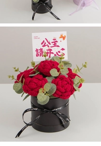 Detail of handcrafted crochet red roses and eucalyptus leaves in a black gift box