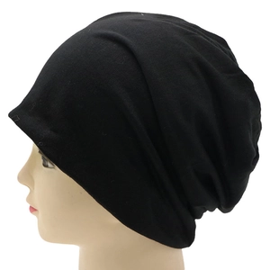 Side view of a black knitted slouchy beanie on a mannequin with detailed fabric texture