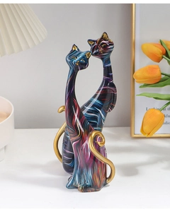 Detail of colorful water transfer cat statues with golden accents in a modern home setting