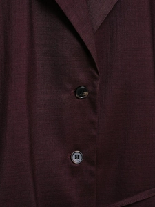 Detail of dark burgundy satin shirt fabric with twill texture and black buttons