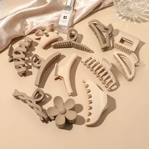 Detail view of matte hair claws in beige and brown tones with elegant silk and perfume