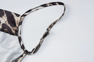 Dettaglio della spallina regolabile con fibbia argentata su abito con stampa leopardata