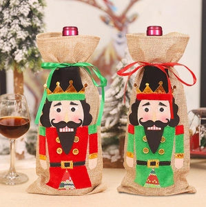 Close-up of red and green nutcracker wine bottle covers with sequin embroidery details