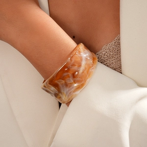 Detail of amber clouded resin acrylic bangle paired with professional blazer outfit