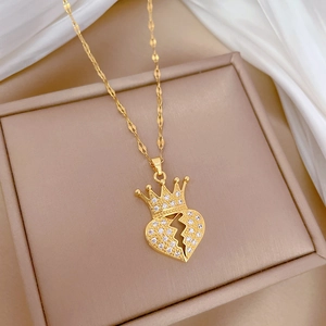 Detailed shot of gold crown broken heart necklace with sparkling crystals in a gift box