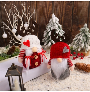 Close-up of Christmas gnomes with reindeer antlers and knit hats in a festive setting