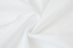 Macro shot of white textile texture with fine stitching and natural fabric folds