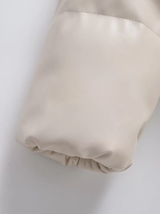 Detailed macro shot of reinforced stitching and faux leather texture on jacket sleeve