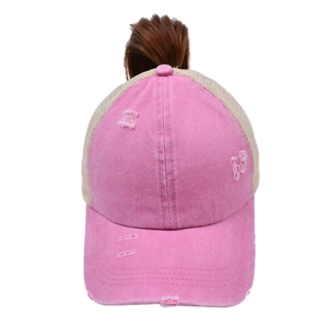 Detail of washed pink ponytail baseball cap showing distressed texture and breathable mesh
