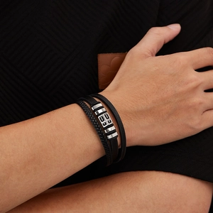 Close-up of men's multi-layer black leather bracelet with decorative metal beads on wrist