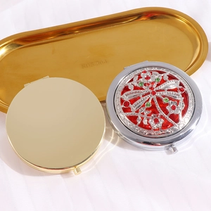 Detailed view of vintage gold and silver folding makeup mirrors with dragonfly jewelry patterns