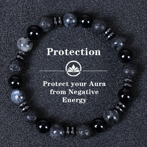 Close-up of triple-layered protection bracelet with tiger eye and obsidian on dark sand