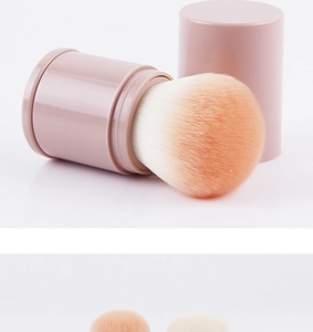 Detailed view of pink retractable makeup brush with orange gradient synthetic bristles