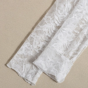 Close-up of intricate white lace floral embroidery and hollow-out mesh on long sleeves
