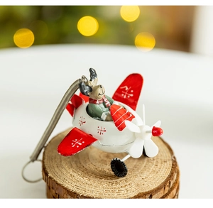 Close-up of reindeer in red airplane ornament on rustic wooden tree trunk base