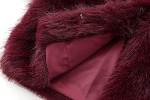 Detailed close-up of luxurious burgundy faux fur jacket with silky smooth lining