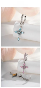 Detail of cross earrings with blue and pink zircons and white stone set silver buckles