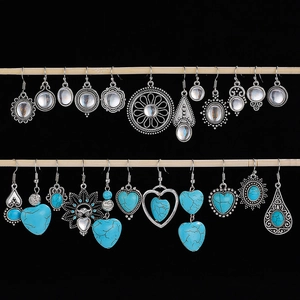 Bohemian silver alloy earrings with turquoise and gemstones on wooden display stand