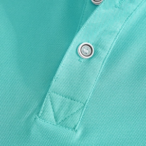 Close-up of turquoise piqué polo shirt fabric texture with decorative button detail
